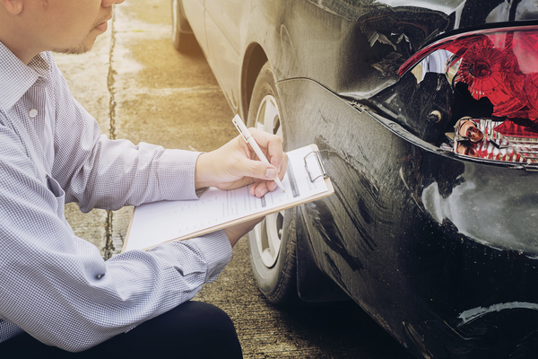 Insurance agent working during on site car accident claim process, people and car insurance claim